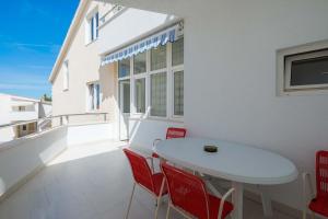 a white table and chairs on a balcony at Apartments and rooms by the sea Duce, Omis - 18155 in Omiš