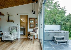 a screened in porch with a chair and a table at Nant-y-coed Lodges in Mochdre