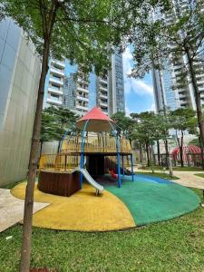 Cozy Studio Suite in Taman Anggrek Residences في جاكرتا: ملعب مع زحليقة في حديقة