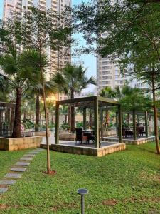 Cozy Studio Suite in Taman Anggrek Residences في جاكرتا: شرفة في حديقة مع أشجار النخيل