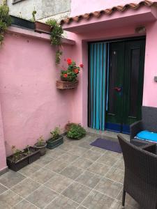 a pink house with a green door and potted plants at Rooms with WiFi Susak, Losinj - 18208 in Susak