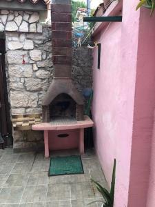 un horno de pizza al aire libre junto a una pared en Rooms with WiFi Susak, Losinj - 18208, en Susak