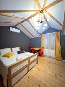 Borjomi Yellow Hotel في بورجومي: غرفة نوم بسرير ومروحة سقف