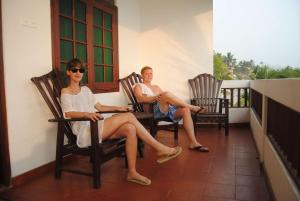 two women sitting in rocking chairs on a porch at La Veranda Di Serena in Unawatuna