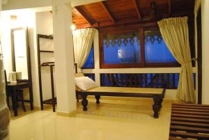 a room with a bench in front of a window at La Veranda Di Serena in Unawatuna