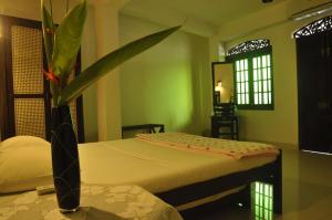 a bedroom with two beds and a potted plant at La Veranda Di Serena in Unawatuna