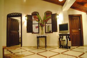 a room with two doors and a tv on the wall at La Veranda Di Serena in Unawatuna