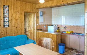 a kitchen with a table and a blue couch in a room at Awesome Apartment In Kopalino With 1 Bedrooms And Wifi in Kopalino