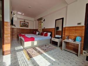 a bedroom with a large bed and a mirror at Matina Regency in Gangtok +19 photos