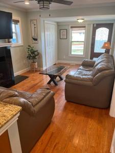 Sala de estar con 2 sofás y mesa de centro en Waterfront Lake Saint Clair Lodge 