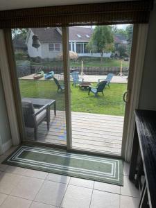 una puerta corredera de cristal que da a un patio con mesa y sillas en Waterfront Lake Saint Clair Lodge 