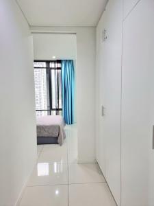 Cette chambre blanche dispose d'un lit et d'une fenêtre. dans l'établissement Studio at The Ridge KL East W, à Kuala Lumpur