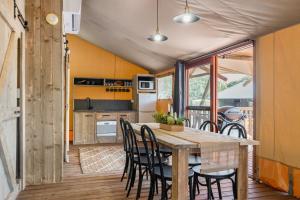 a kitchen and dining room with a wooden table and chairs at Ballina Beach Nature Resort in Ballina
