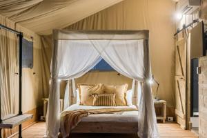 ein Schlafzimmer mit einem Himmelbett und einem Fenster in der Unterkunft Ballina Beach Nature Resort in Ballina