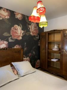 - une chambre avec une fresque murale florale et un lit dans l'établissement Chez Paul et Louis, à Rodez