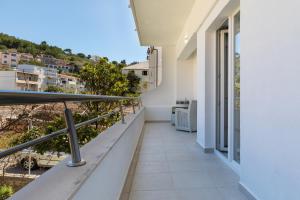 a balcony of a building with a view of a city at Apartments by the sea Sumpetar, Omis - 18286 in Jesenice