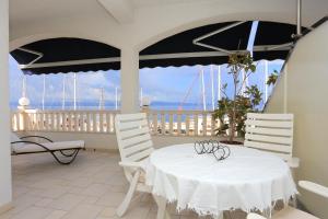 a white table and chairs on a balcony with the ocean at Apartments by the sea Sumpetar, Omis - 18286 in Jesenice