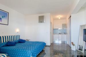 a bedroom with a blue bed and a kitchen at Apartments by the sea Sumpetar, Omis - 18286 in Jesenice