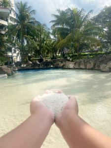 a person holding a beach ball in front of a pool of water at Grand Tropic Suites Hotel in Jakarta