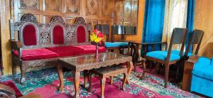 1 dormitorio con 1 cama, mesa y sillas en New Silver Jubilee Heritage Group Of Houseboats, en Srinagar
