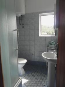 ein Badezimmer mit Waschbecken und Toilette und einem Fenster in der Unterkunft Apartments by the sea Kampor, Rab - 18268 in Rab