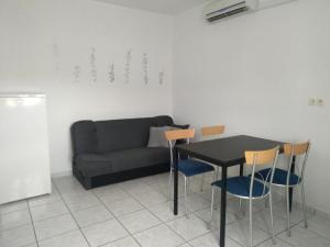 ein Wohnzimmer mit einer Couch und einem Tisch und Stühlen in der Unterkunft Apartments by the sea Kampor, Rab - 18268 in Rab + 18 Fotos
