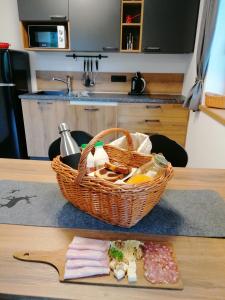 ein Korb mit Lebensmitteln, der auf einem Tisch mit einem Teller liegt in der Unterkunft Apartments Gorski raj in Kranjska Gora