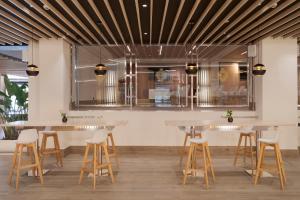 a bar with tables and stools in a restaurant at Melia Alicante in Alicante