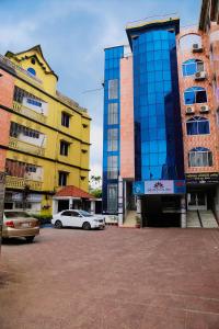 a group of buildings with cars parked in a parking lot at Sreemangal Inn Hotel & Restaurant in Sreemangal