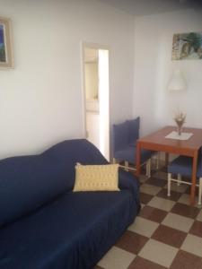 ein Wohnzimmer mit einem blauen Sofa und einem Tisch in der Unterkunft Apartments by the sea Brna, Korcula - 18288 in Smokvica