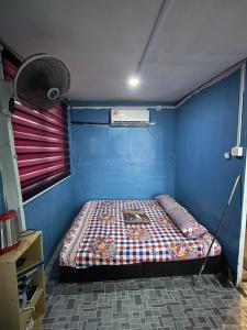 ein kleines Schlafzimmer mit einem Bett in einem blauen Zimmer in der Unterkunft Z&Z Budget Room in Kampung Kuala Besut