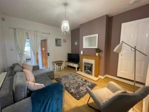 a living room with a couch and chairs and a fireplace at URBAN CITY SUITES 4 bed house, garden, Ideal for Contractors&Families in Quinton