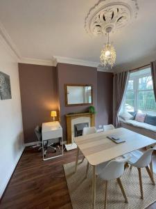 een woonkamer met een tafel en stoelen en een bank bij URBAN CITY SUITES 4 bed house, garden, Ideal for Contractors&Families in Quinton