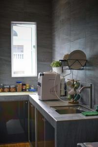 eine Küchentheke mit einer Spüle und einer Mikrowelle in der Unterkunft Amoris Grand Event Space in Muar
