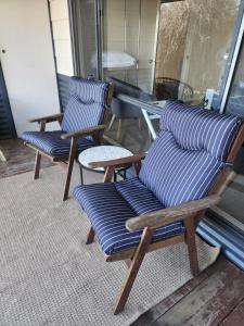a couple of chairs sitting on a porch at Yvonnes Rest Holiday Home in Bridgetown
