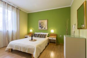 una camera da letto con pareti verdi, un letto e una finestra di Apartments with a parking space Fazana - 18334 a Fažana