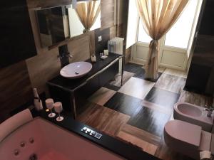 La salle de bains est pourvue d'une baignoire rose et d'un lavabo. dans l'établissement Donna Teresa, à Naples