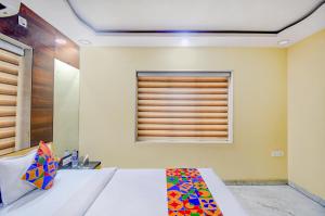 een slaapkamer met een bed en een raam bij FabHotel Divira Inn in Calcutta