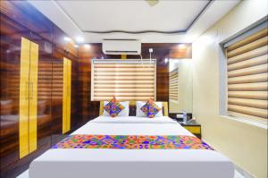 een slaapkamer met een groot bed in een kamer bij FabHotel Divira Inn in Calcutta