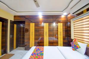 een slaapkamer met een bed en een houten muur bij FabHotel Divira Inn in Calcutta
