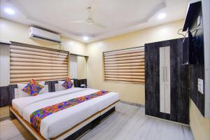a bedroom with a large bed in a room at FabHotel Divira Inn in Kolkata