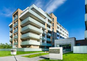 un grand bâtiment avec une enseigne devant dans l'établissement Apartament Kasprowicza, à Kołobrzeg