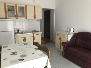 a small kitchen with a table and a couch at Apartments with a parking space Kamenjak, Crikvenica - 18348 in Grižane