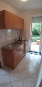 a kitchen with a counter and a sink and a window at Apartments with a parking space Kamenjak, Crikvenica - 18348 in Grižane