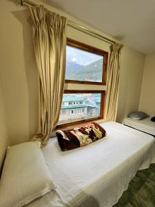 1 cama en un dormitorio con ventana en Hotel Camp de Base, en Namche