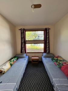 two beds in a room with a window at Hotel Camp de Base in Namche