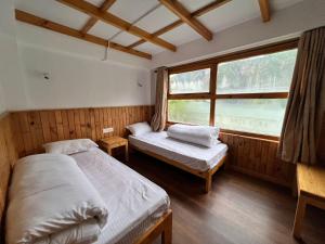 a bedroom with two beds and a window at Hotel Camp de Base in Namche