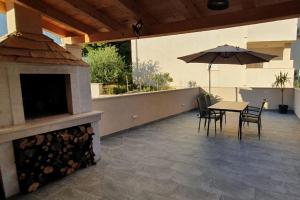 une terrasse avec une table et un parasol dans l'établissement Apartments with a parking space Bol, Brac - 18358, à Bol