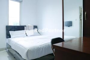 - une chambre avec un grand lit blanc et un bureau dans l'établissement BSD Victory Homestay Mitra RedDoorz, à Dadap