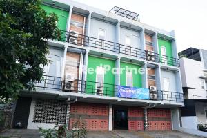 un bâtiment avec un panneau sur son côté dans l'établissement BSD Victory Homestay Mitra RedDoorz, à Dadap